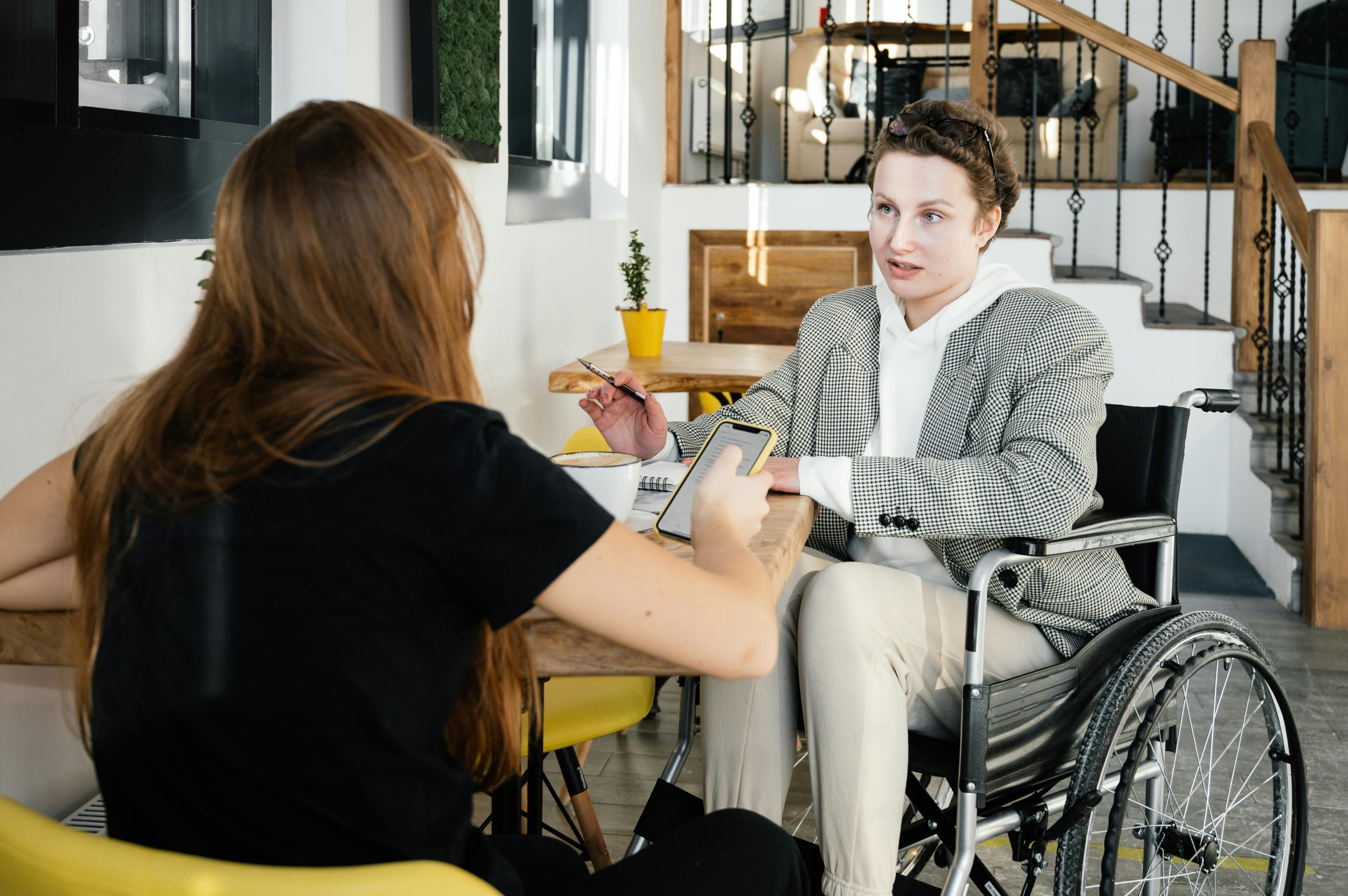 Photo of two individuals speaking at a café.