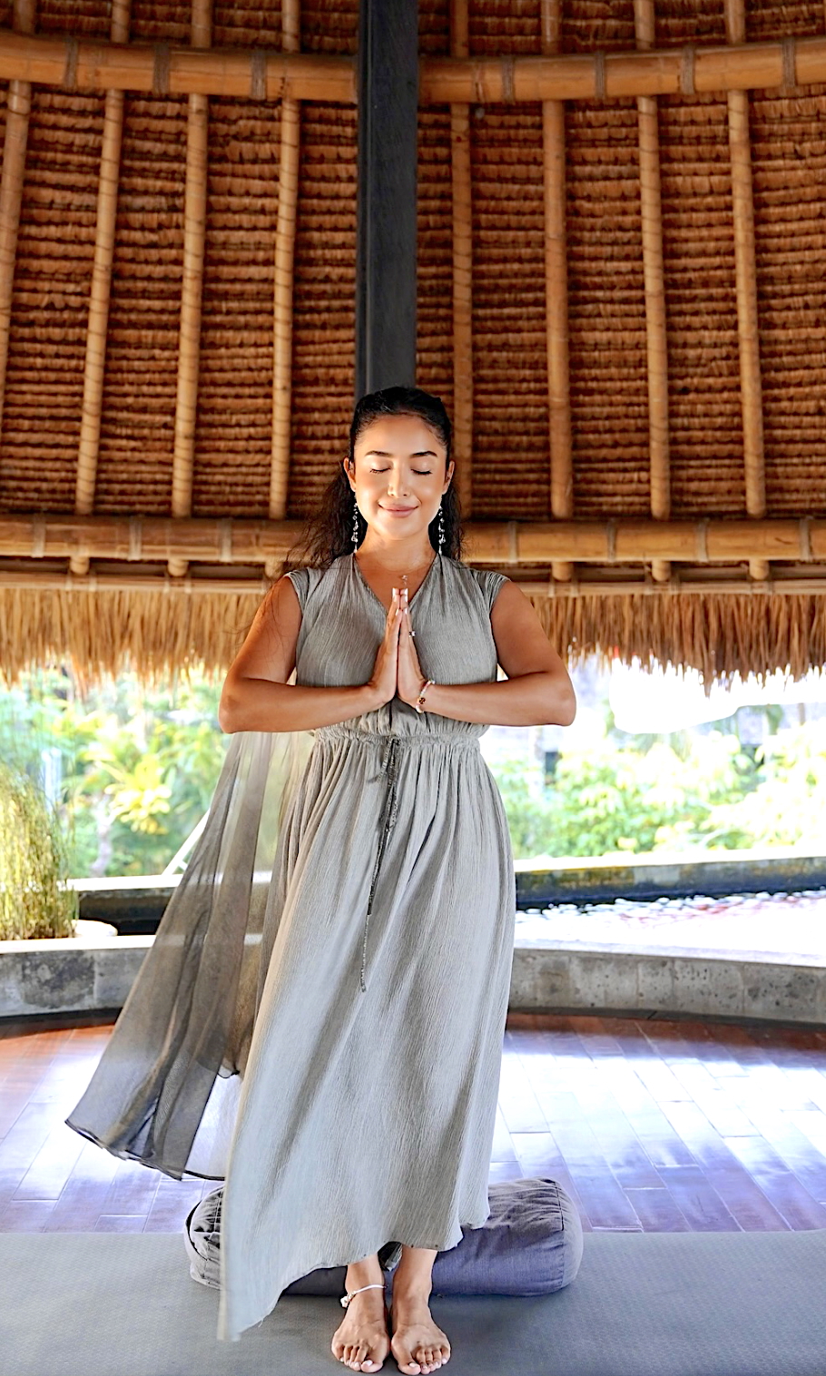 A picture of Dulce meditating while standing in Bali.