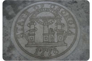 Figure 1. A picture of the Seal of the state of Georgia (dated 1776), engraved into stone. The description on the seal has three columns labeled “wisdom,” “justice,” and “moderation,” with a semi-circle labeled “constitution connecting the three. Photo by Gary Lee Todd under CC0 1.0 public domain license.