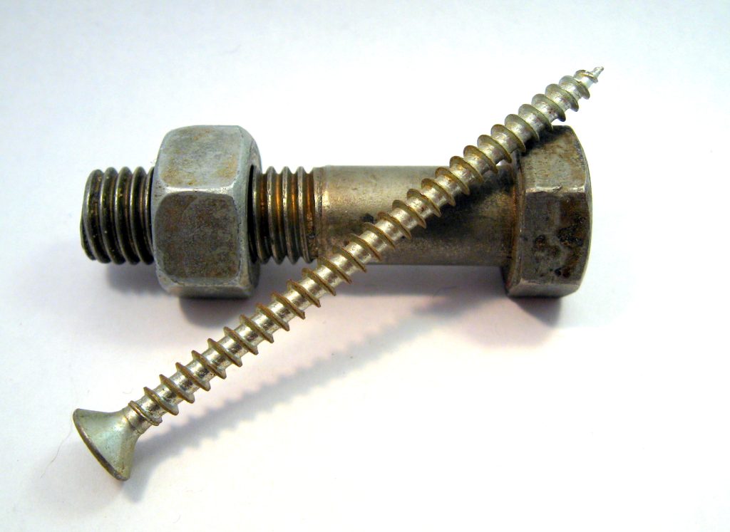 A photograph of a metal bolt (with nut screwed on) and a screw.