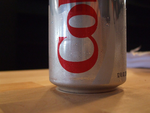 A photograph of beads of condensation covering an aluminum can of Diet Coke.