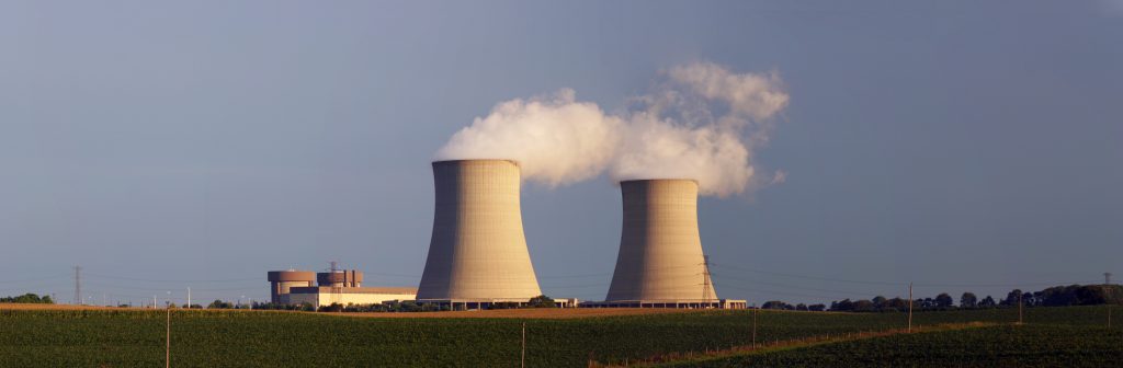 A photograph of the Byron Nuclear Generating Station. There are two large concrete structures (cooling towers) and a smaller building. Both cooling towers have steam emanating from the top.