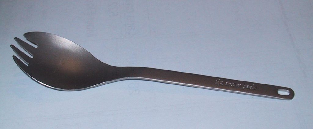 A photograph of a spork, which is a utensil that is both a spoon and a fork at the same time.