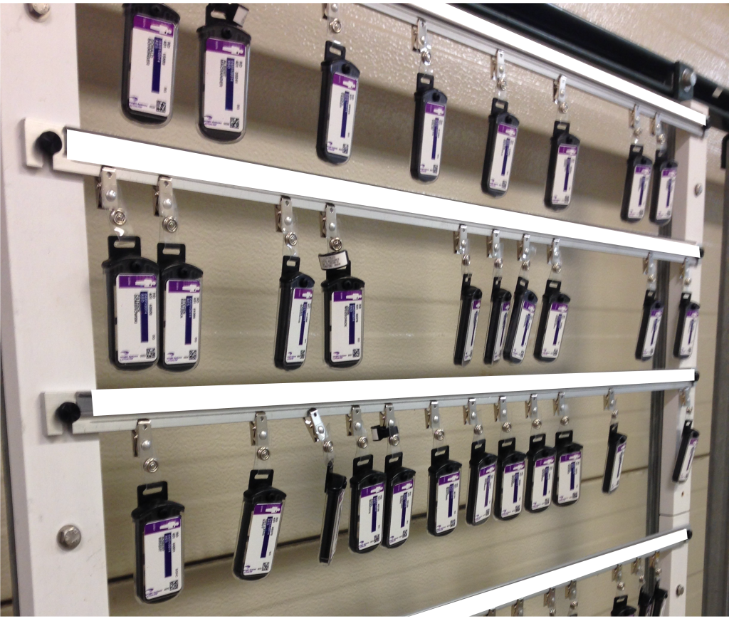 A photograph of many rows of dosimeters hanging on a wall.