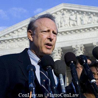 Photograph of Dick Heller speaking into a microphone