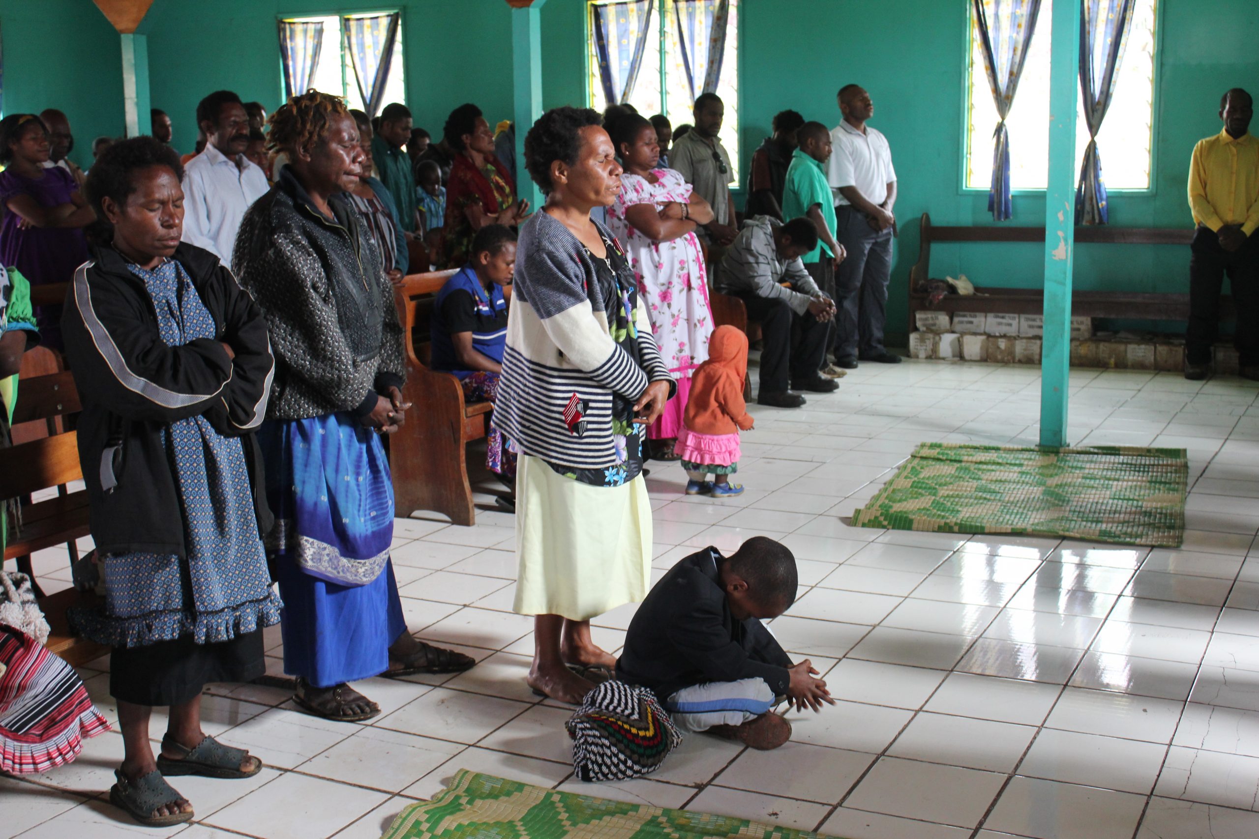Candid photography of parishioners at Lutheran church service in Papua New Guinea.