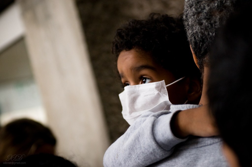 Photo showing a masked child looking off to side