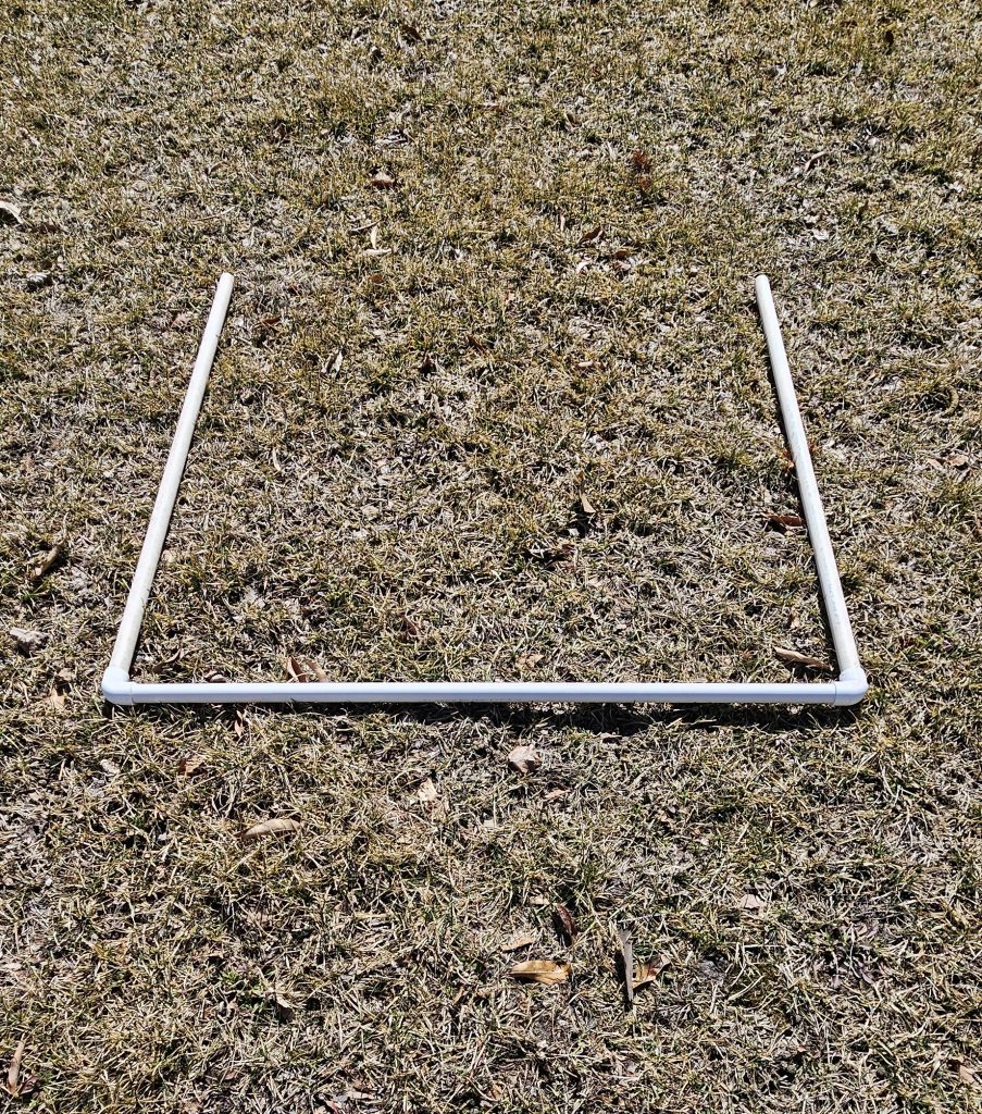 A photo of a 1-m2 quadrat frame with 3 sides made from 0.75-inch PVC pipes and elbows, as assembled for this lab.