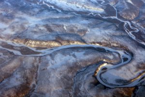 Aerial photograph of curving streams across frozen land in Northern Siberia.