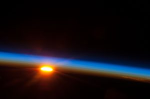 Photograph from space, showing sunrise over the Pacific Ocean.