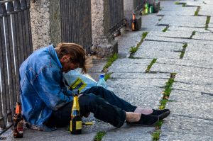 Photograph showing a drunk man, slumped on the sidewalk in St. Petersburg, Russia..