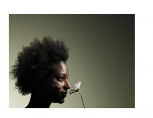 Black woman smelling a daisy with the word smell painted on her cheek