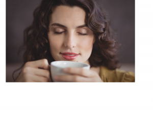 Woman with a cup smelling whats inside
